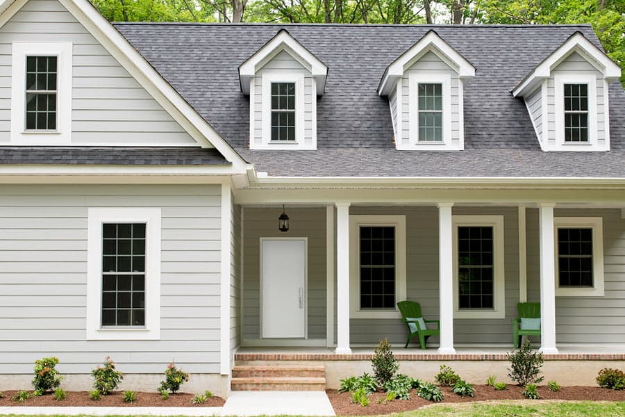 White Steel entry door two-story home with white double hung windows