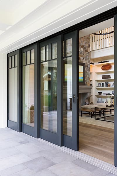 Four panels of a black pocket door with the closest panel partially open