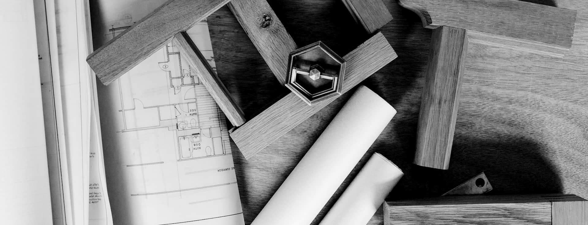 A black and white image of architectural drawings and tools.