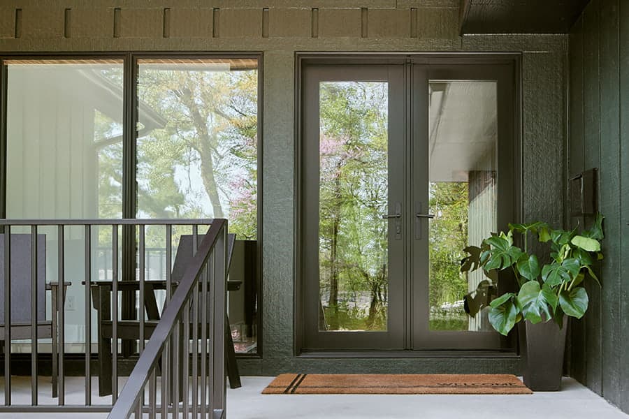 Two Story home with triple white window panes and double wood entry door