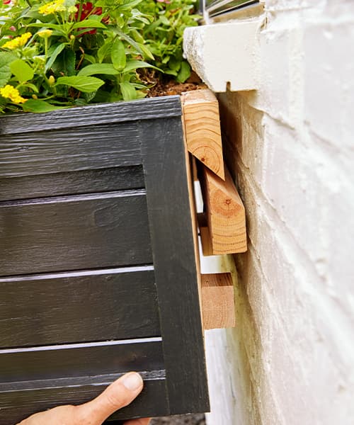 Hanging a window box onto the cleat board that's been attached to the home exterior