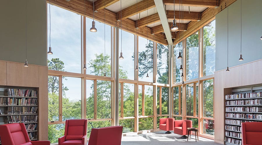 interior of a library with red chairs and window walls
