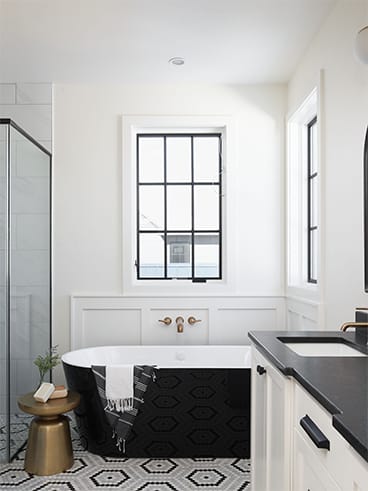 Black windows on a white wall over a black soaker tub