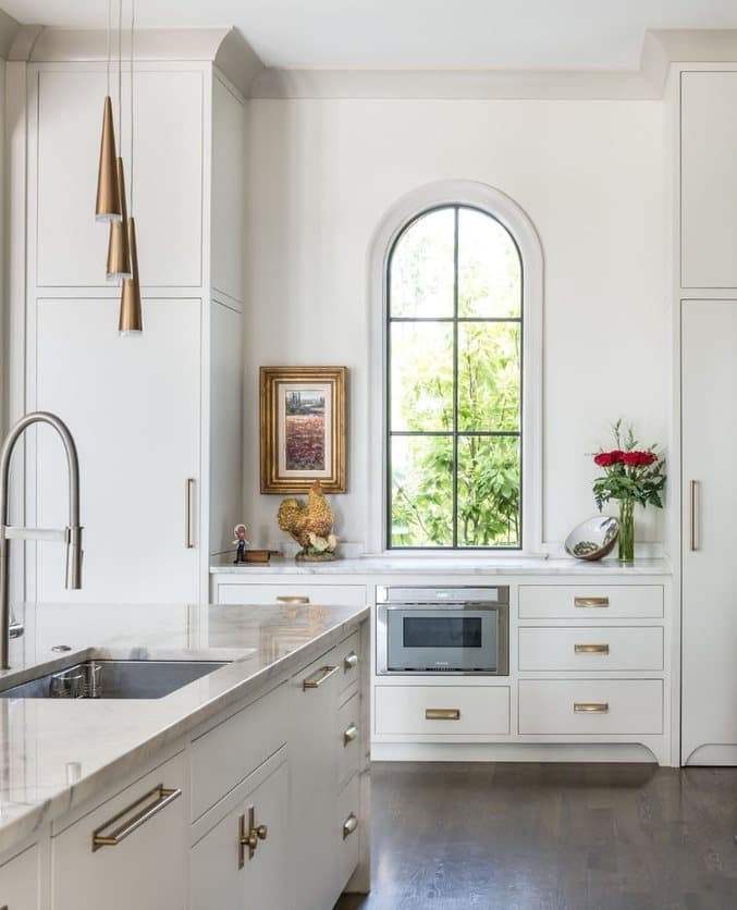 A black arch window with simple grille pattern above the kitchen counter.