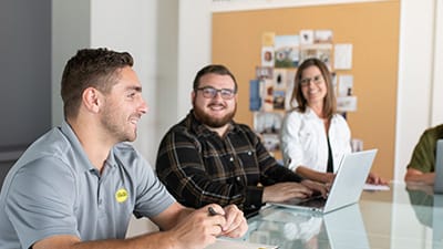 A team of corporate workers are meeting with a new intern to welcome him.